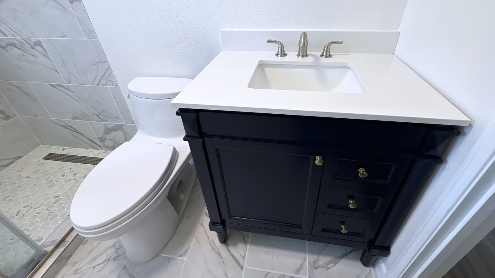 Bathroom vanity installation with quartz countertop and modern fixtures in a clean interior space